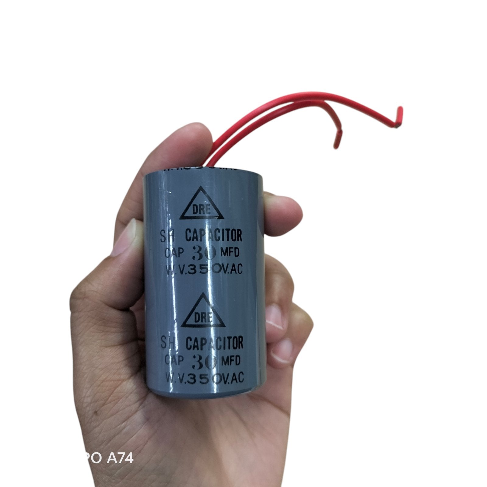 SH 30uf 350v run capacitor 350v in hand with red wires for electrical applications