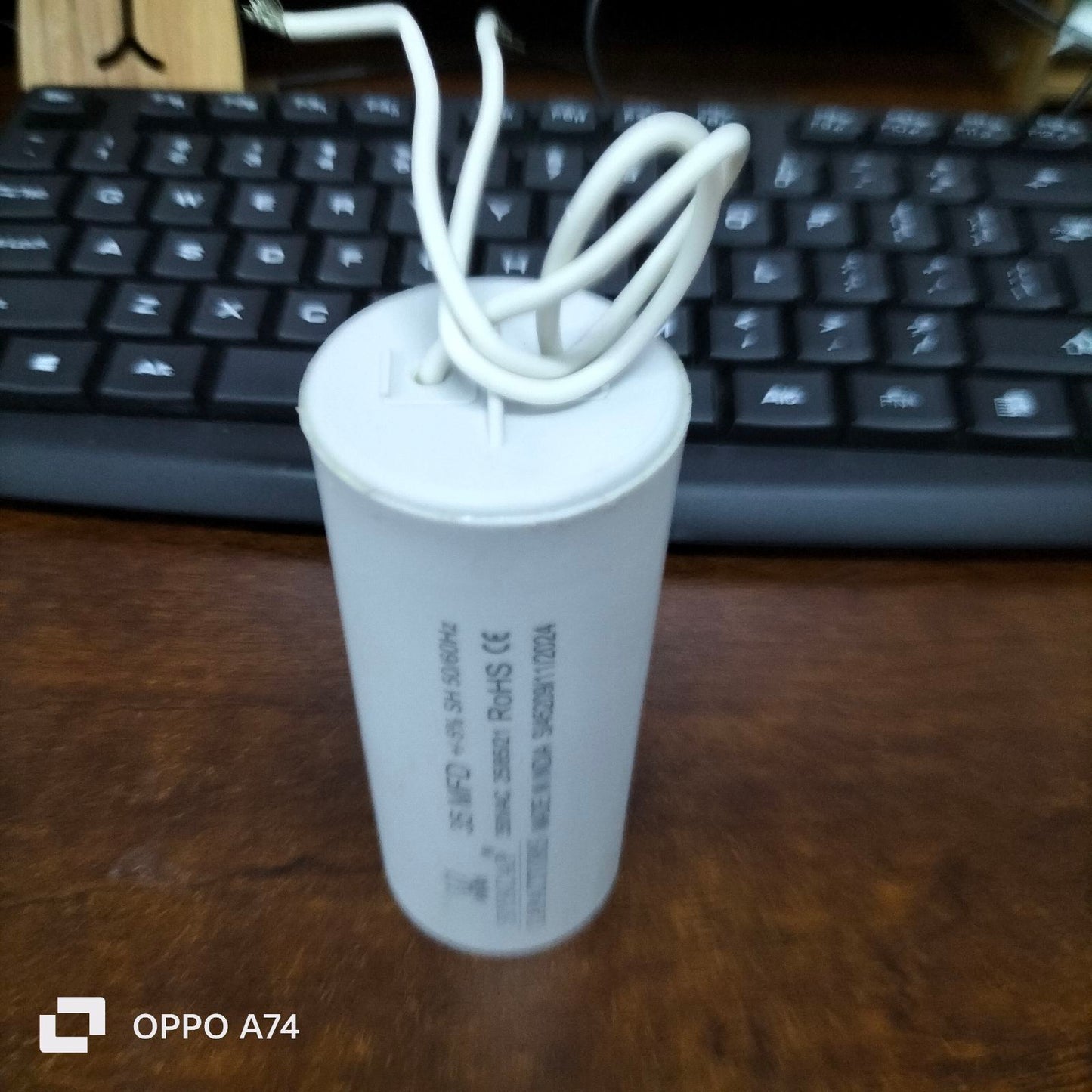 Syscap 35MFD 350 VAC Running Capacitor cylindrical electrical part with white wires on wooden desk