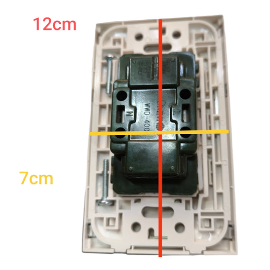 A rear view of a wall switch plate showing the back of a dark green electrical contact block mounted in a beige plastic cover, with overlaid dimension lines indicating 12cm width, 7cm height, and a vertical center line.