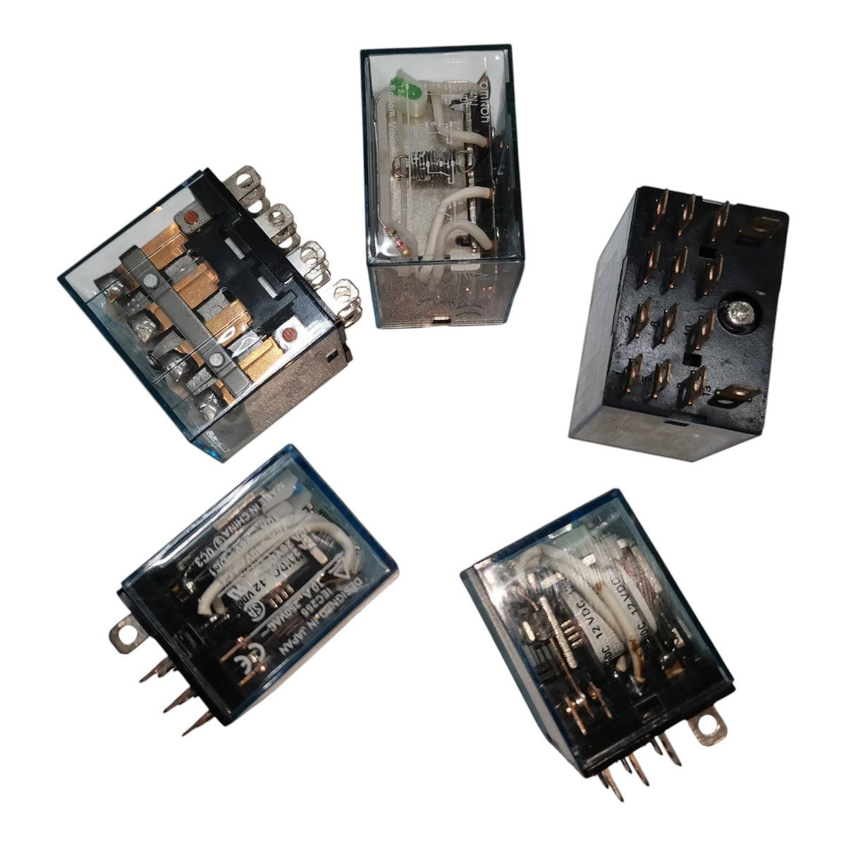 Five industrial electrical relays with transparent housings, showing internal components, wiring, and metal terminals, arranged on a plain white background.