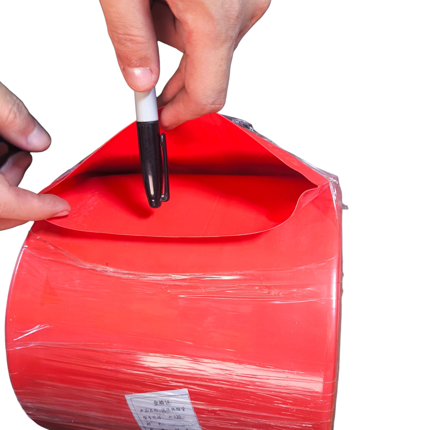 Person opening a red parcel with a pen on a white background