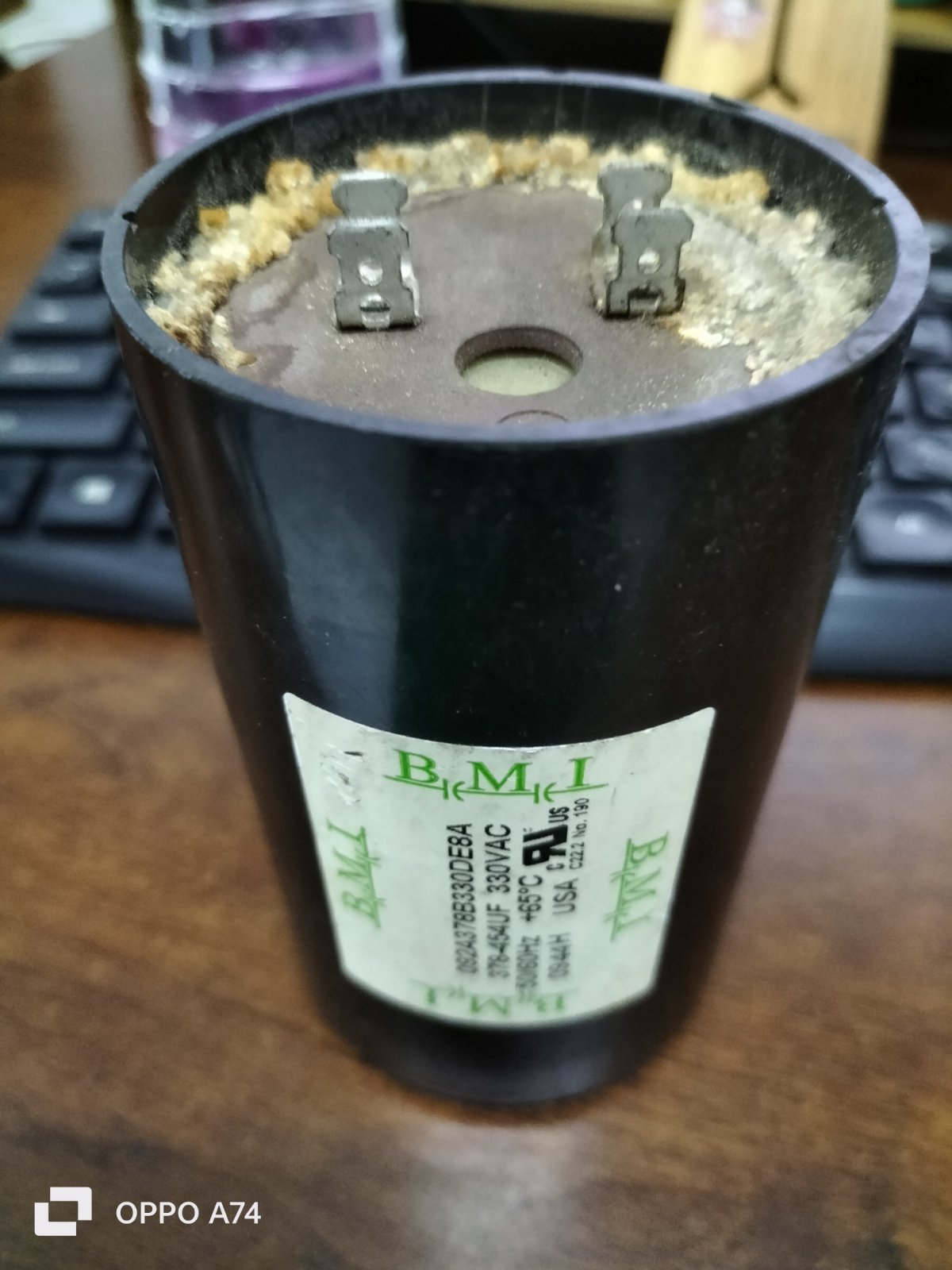 BMI 378-454UF starting capacitor electrical component with dual terminals on wood surface