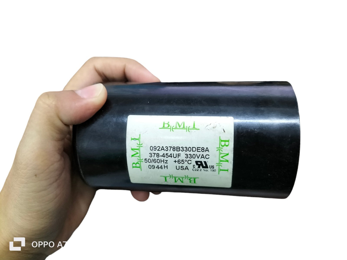 BMI 378-454UF starting capacitor 330VAC electrical circuitry part held in hand