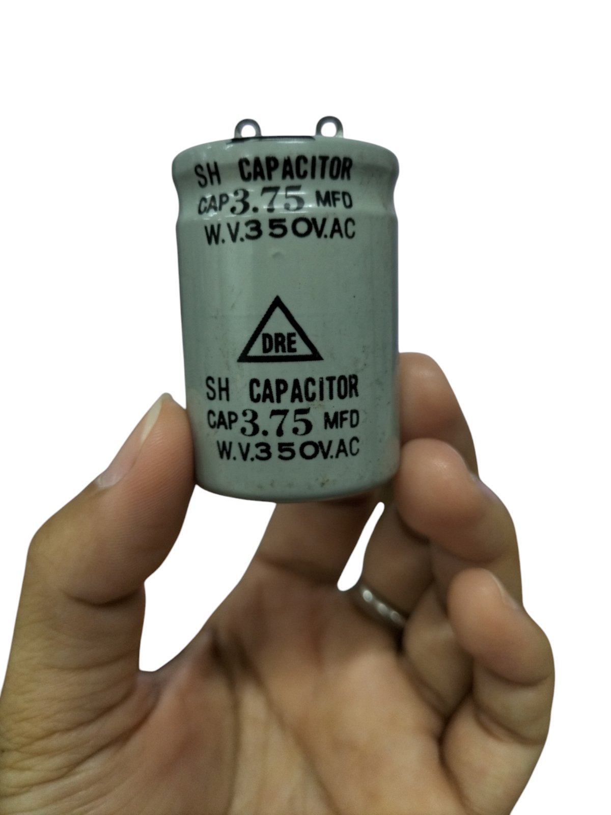 Hand holding DRE 3.75 MFD motor running capacitor with 350V AC rating for electrical circuitry