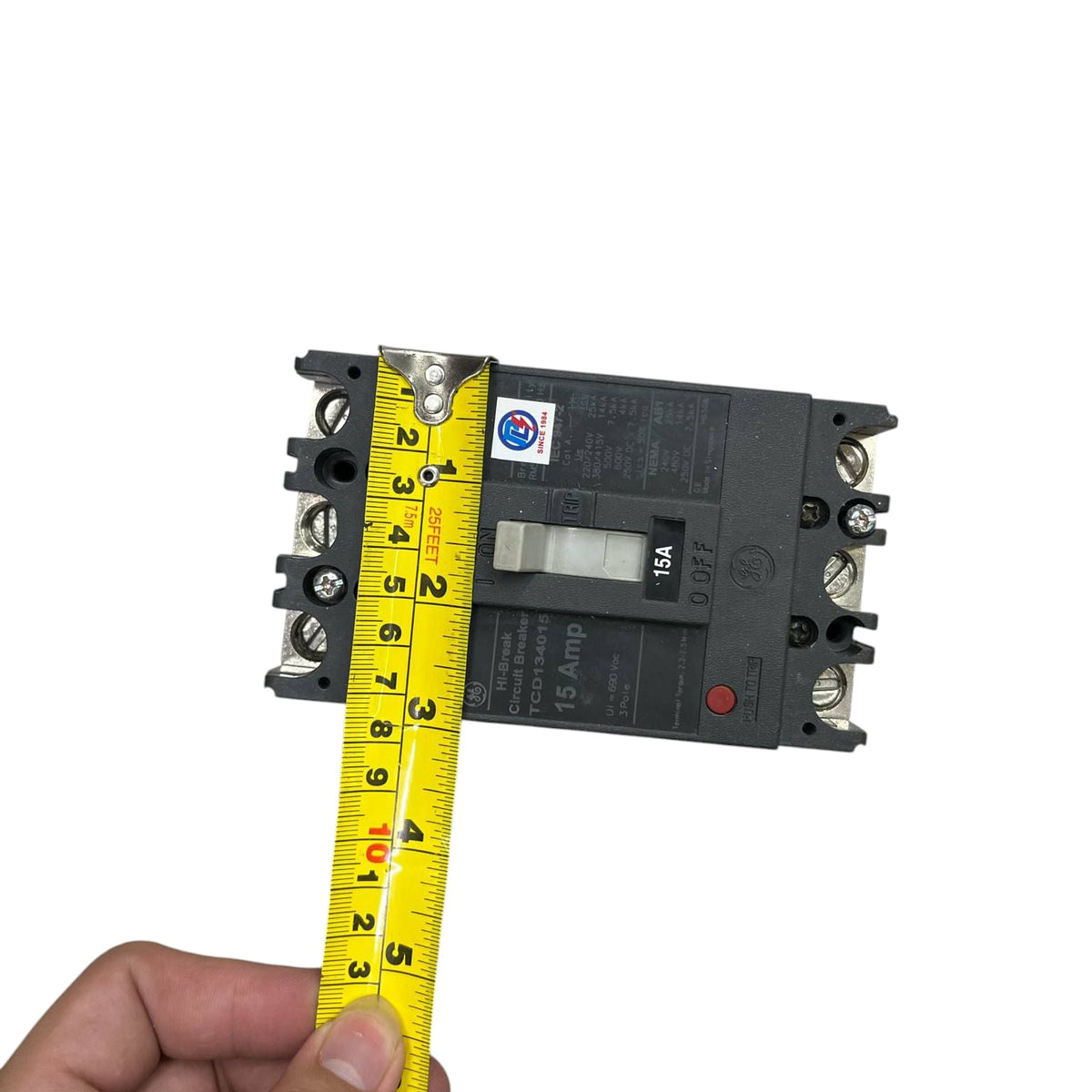 GE 15A 3Pole Industrial Circuit Breaker 220V held with tape measure showing size