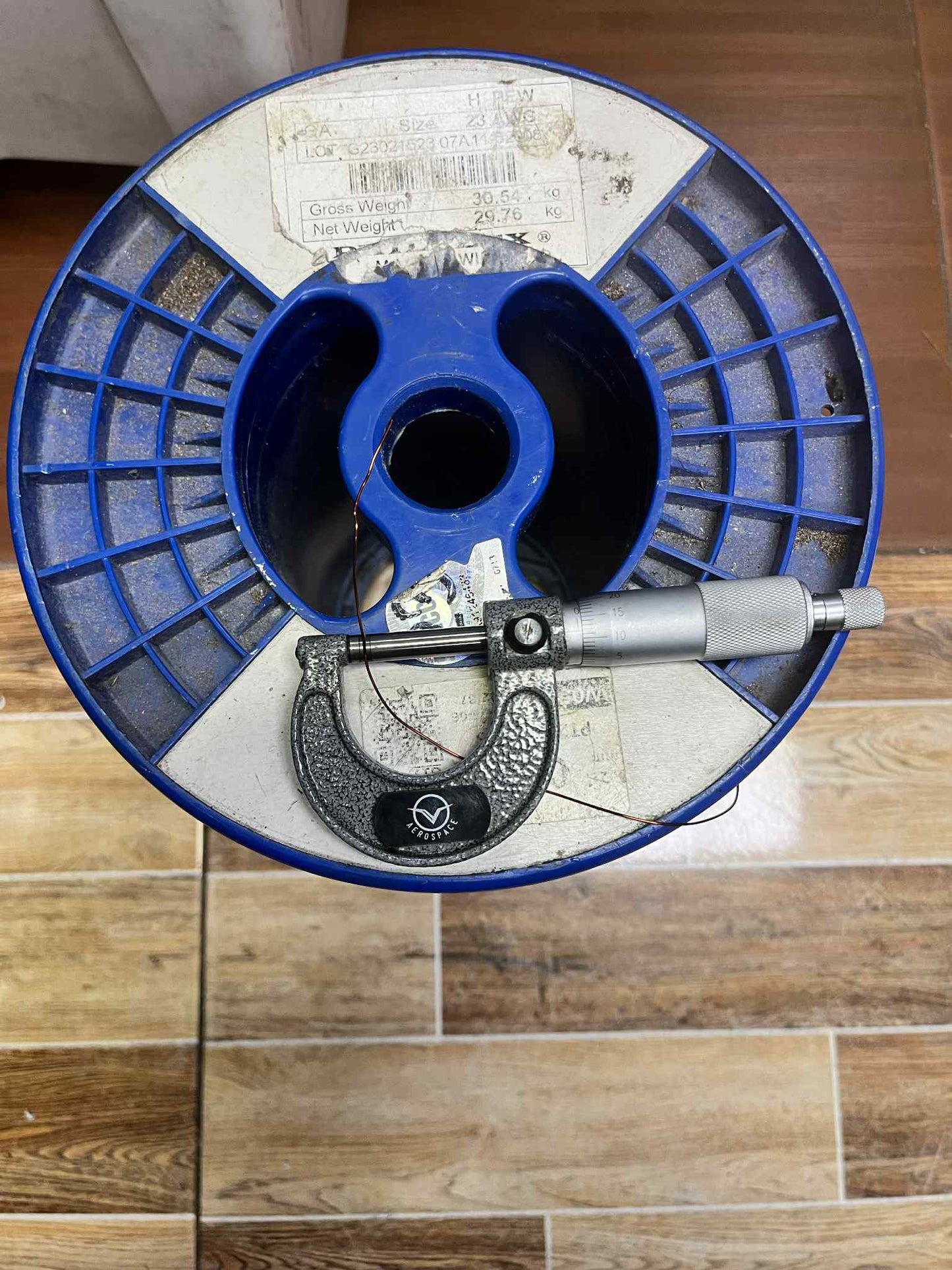 Philflex heavy Formix magnet wire AWG 23 400G on a spool with a measuring tool