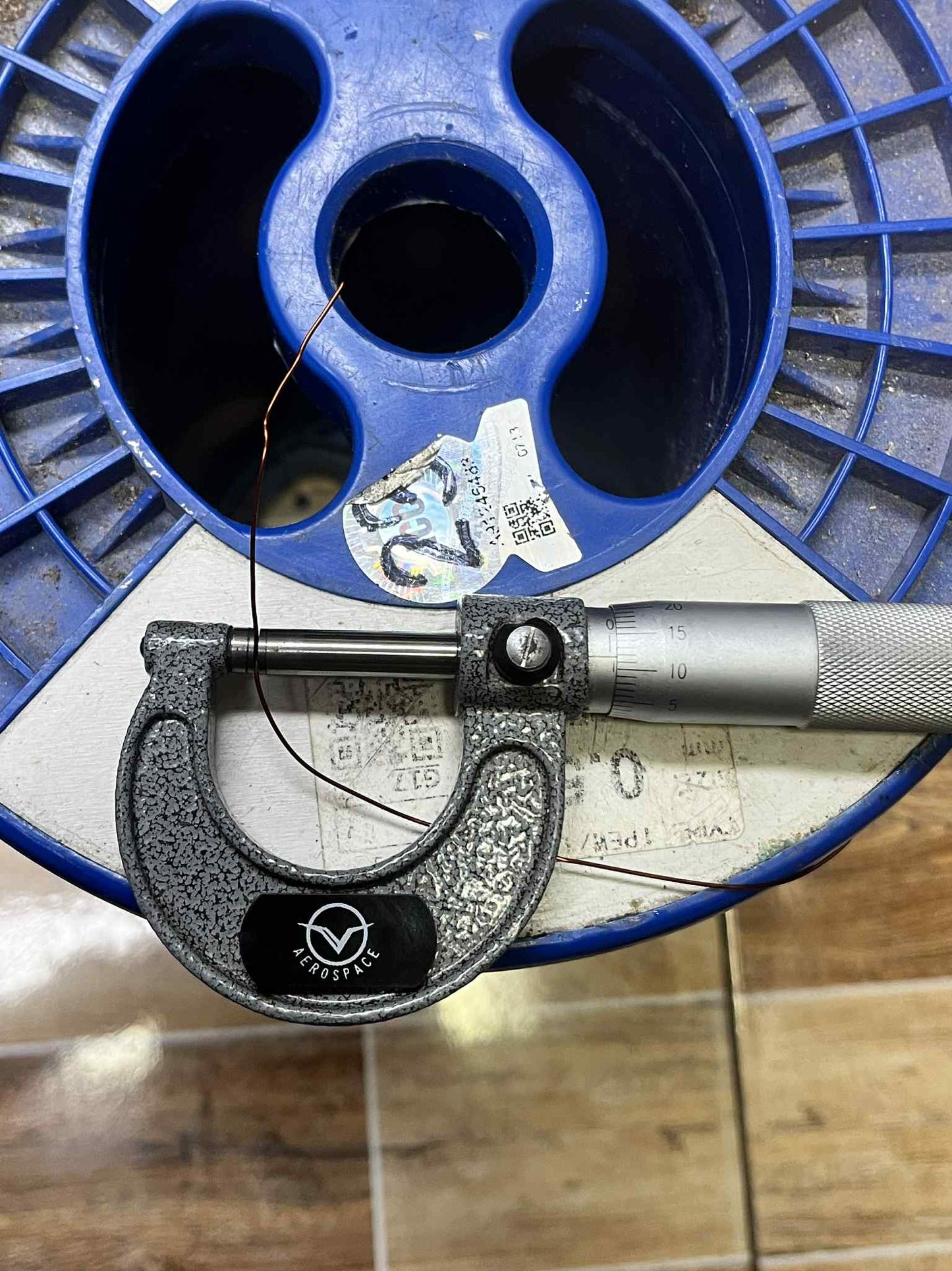Heavy Formix magnet wire AWG 23 600G measured with a micrometer on a blue spool