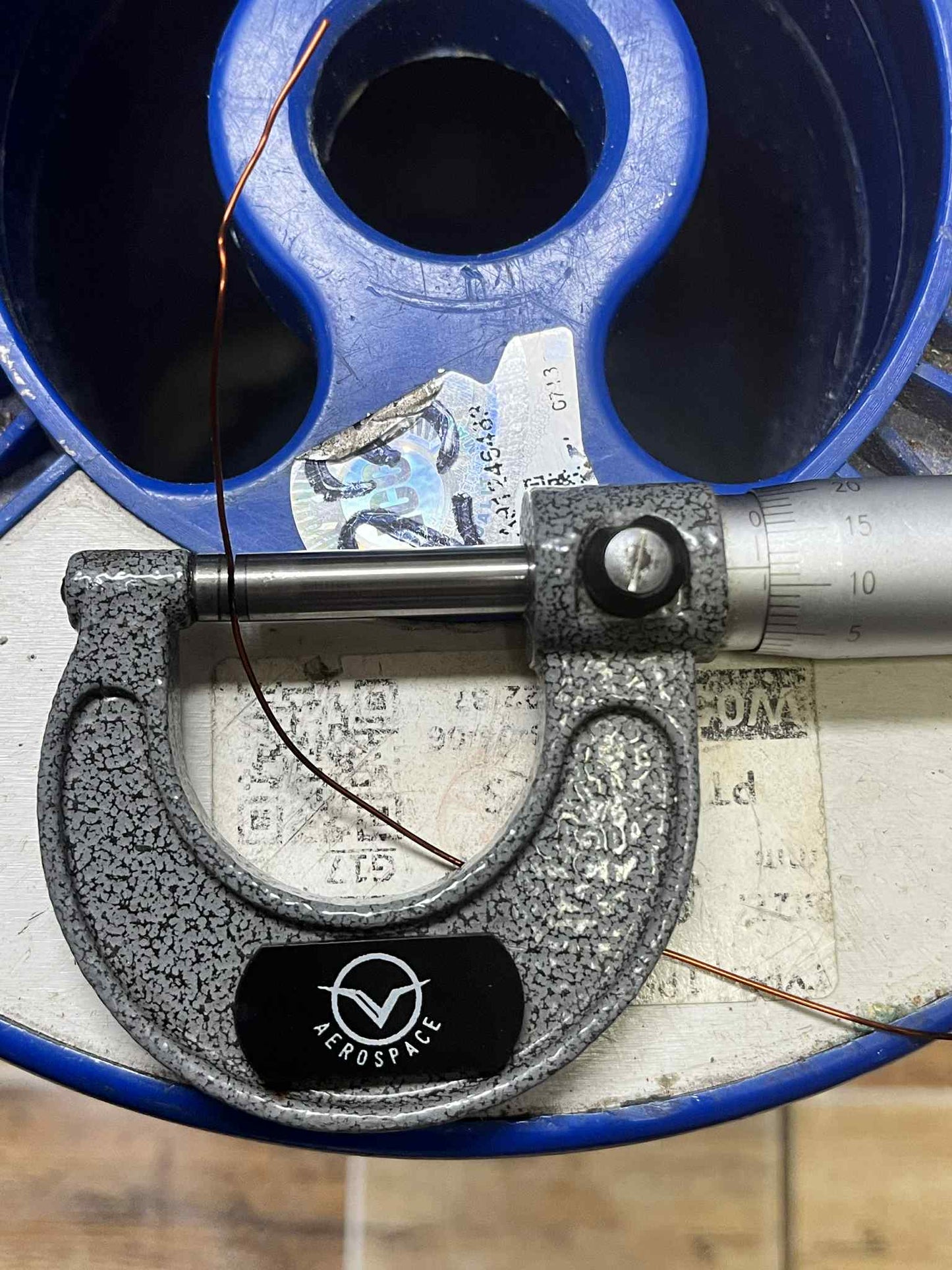 Measuring Heavy Formix magnet wire AWG 23 600G with a micrometer on a blue reel