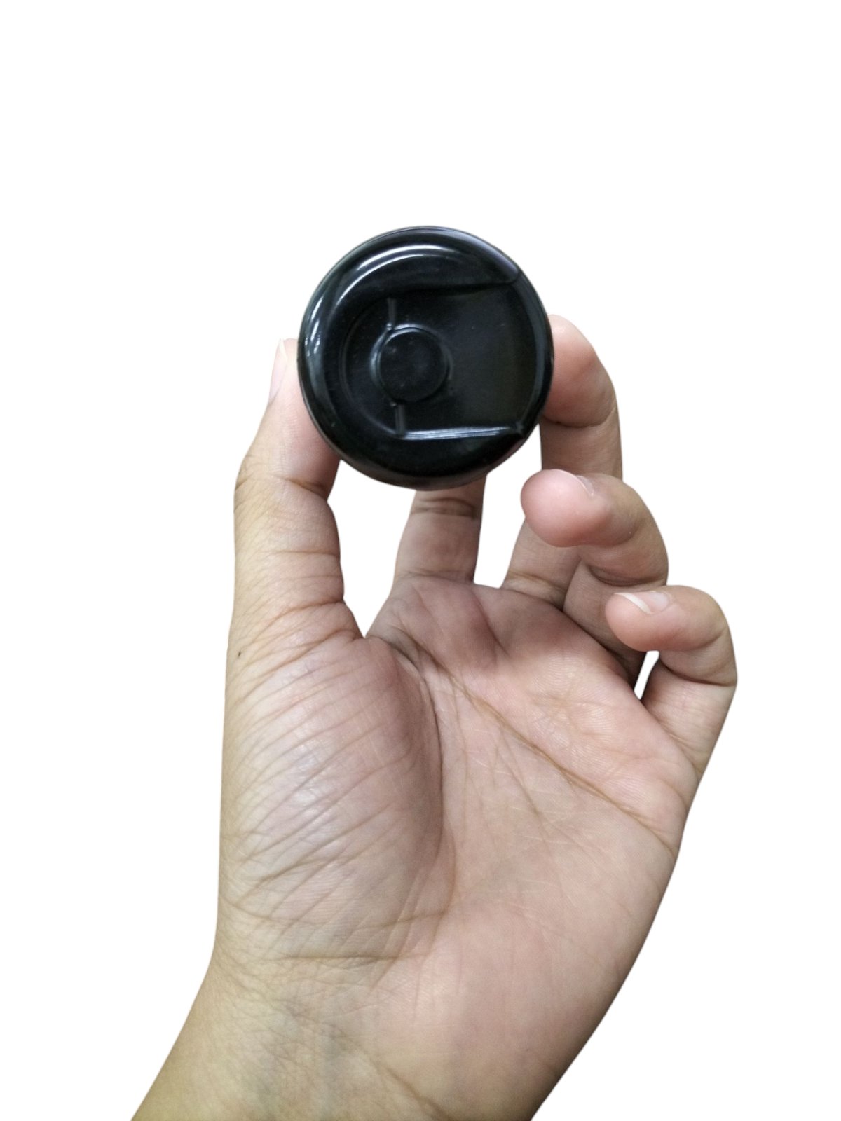 Hand holding a black Mallory motor capacitor electrical circuitry part against a white background