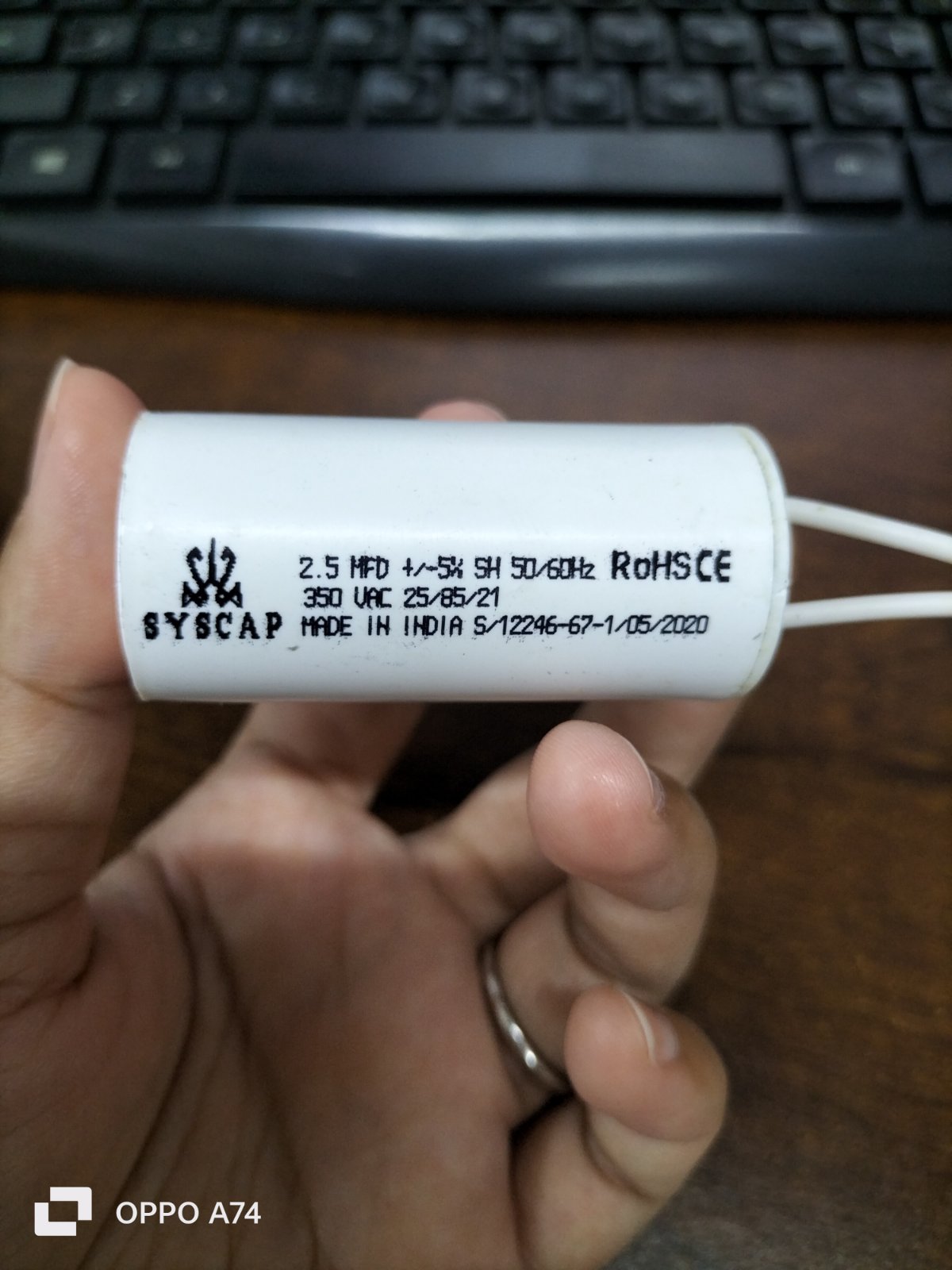 Syscap Motor Running Capacitor 2.5MFD white cylindrical electrical component held in hand