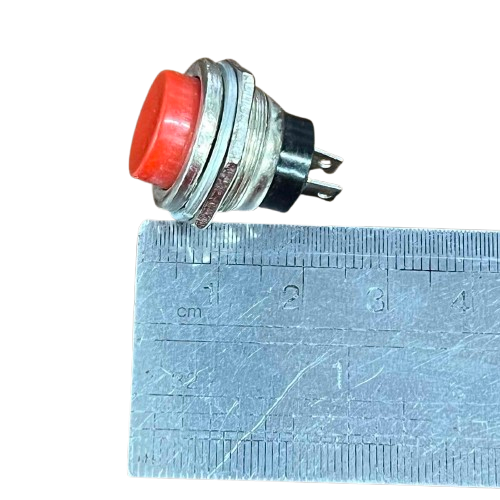 Normally Open Switch 1A Red 220V beside a ruler for size comparison