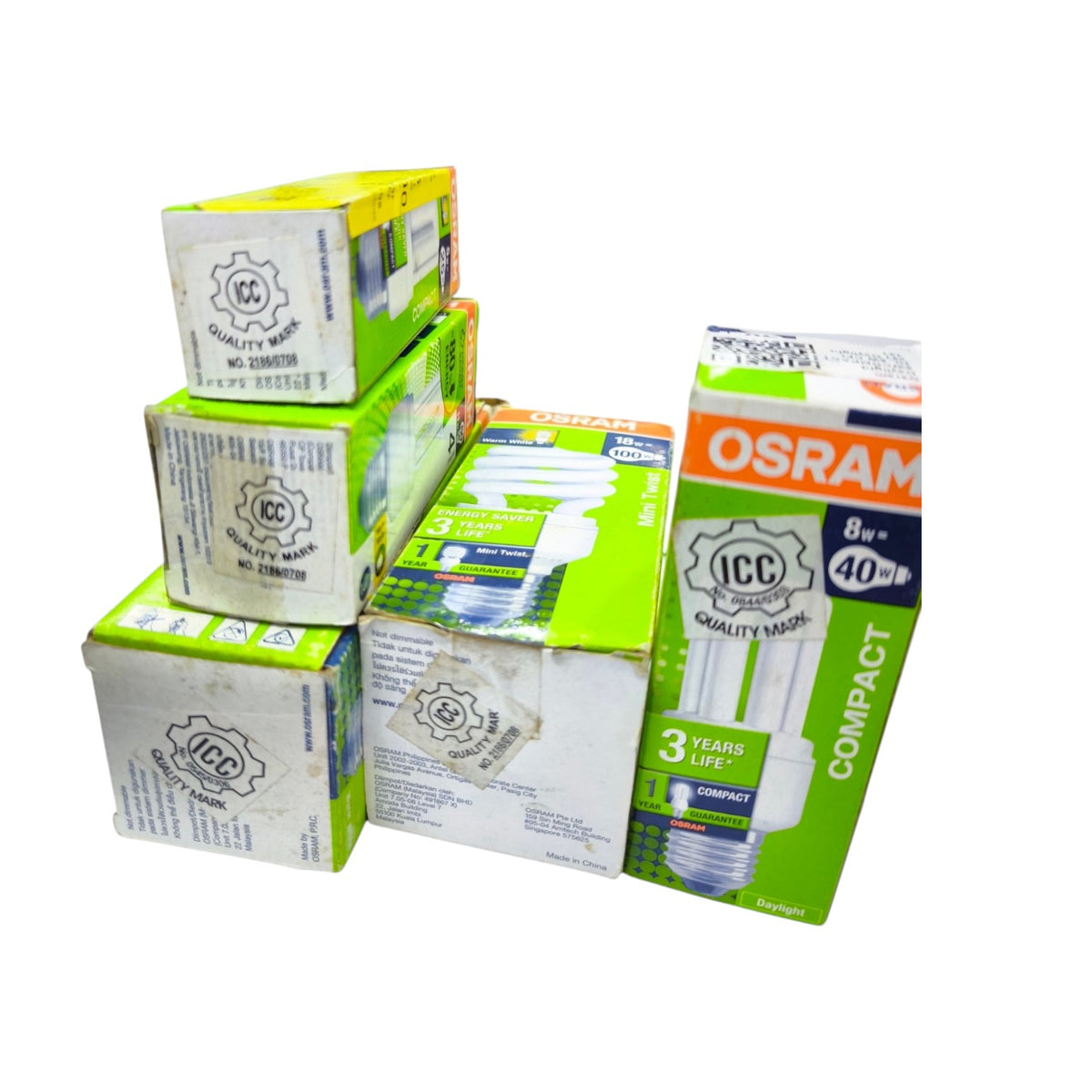 Five boxes of compact fluorescent light bulbs (CFLs) from OSRAM and ICC Quality Mark, arranged on a plain white background.