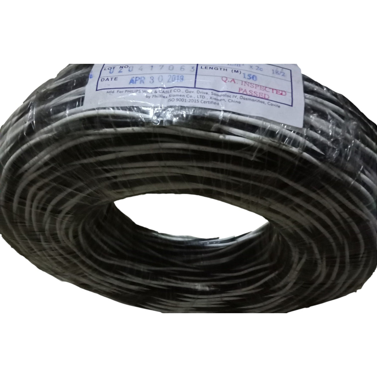 Coiled black cable with a label on a white background