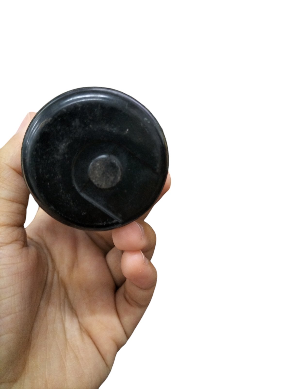 Hand holding a black BMI Motor Starting Capacitor 324-389 MFD for electrical circuitry and parts