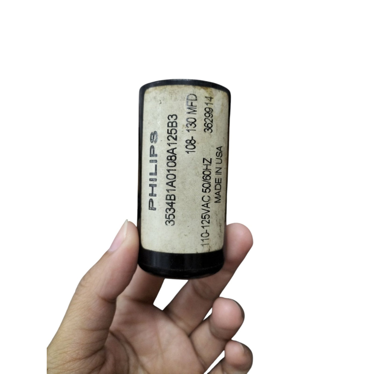 Philips Starting Capacitor 108-130 MFD held in hand, designed for electrical circuitry applications