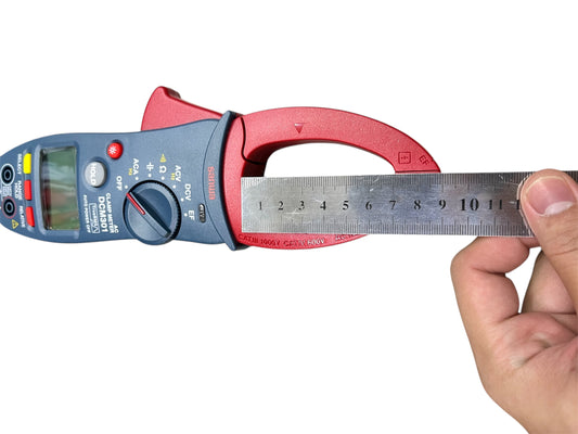 Sanwa Digital AC Clamp Meter DCM301 held by hand measuring with a metal ruler for electrical testing
