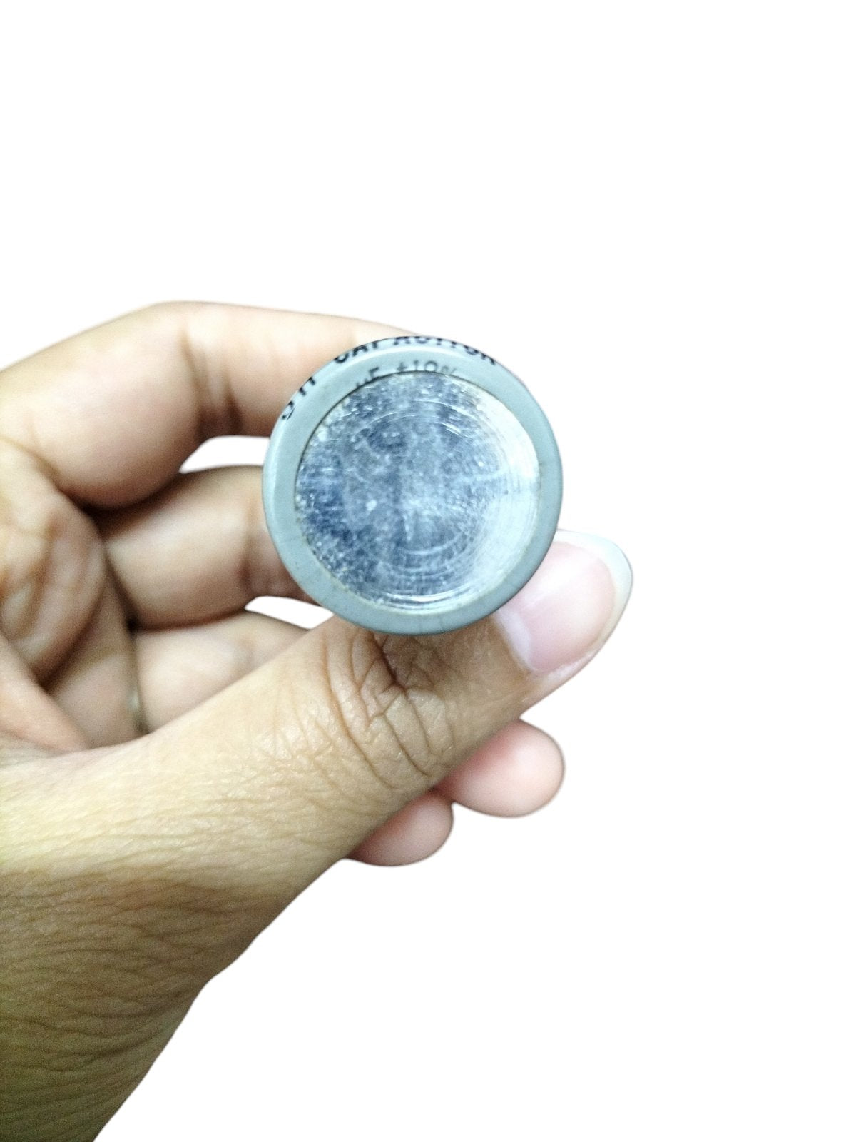 Hand holding a 0.5MFD Motor Running Capacitor electrical component made in Taiwan