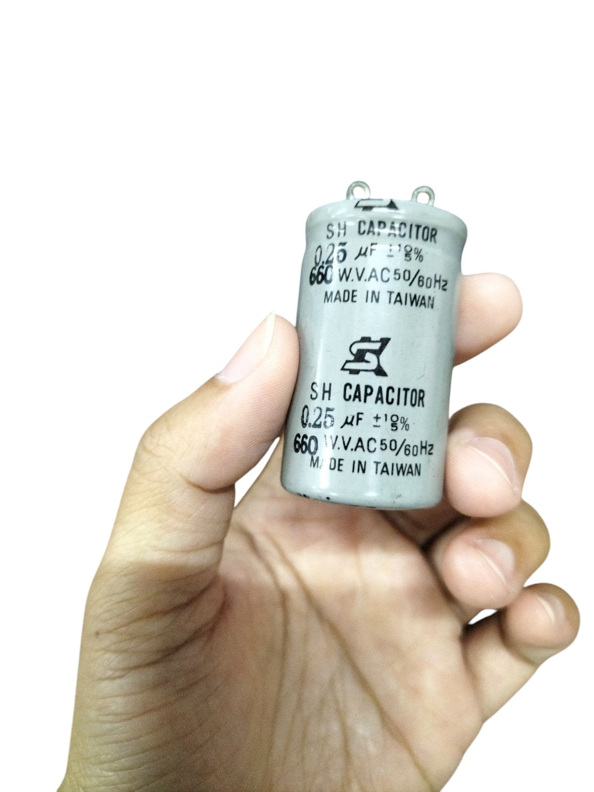 SH Motor Running Capacitor 0.25UF 660V AC held in hand showing electrical circuitry part details