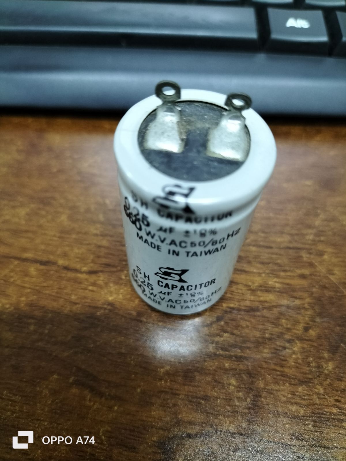 SH Motor Running Capacitor 0.25UF 660V AC cylindrical electrical component on wooden surface