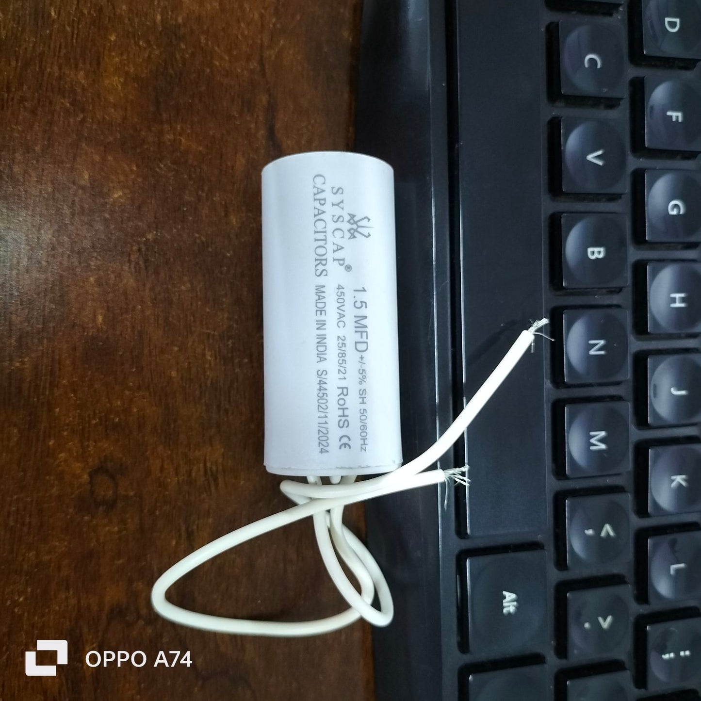 Syscap 1.5MFD 450V AC Motor Run Capacitor white cylindrical electrical component near keyboard