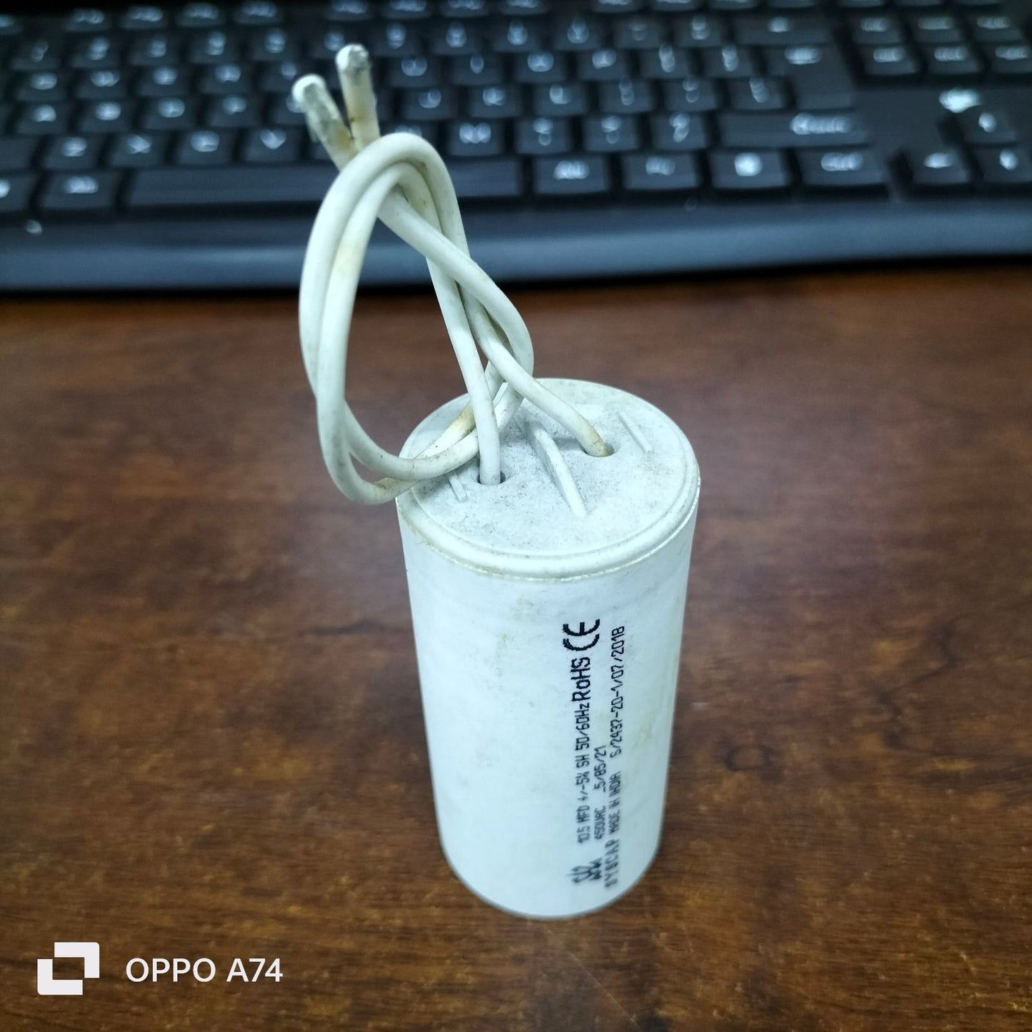 Syscap 10.5MFD 450 VAC Running Capacitor white cylindrical electrical component with wires on wooden table