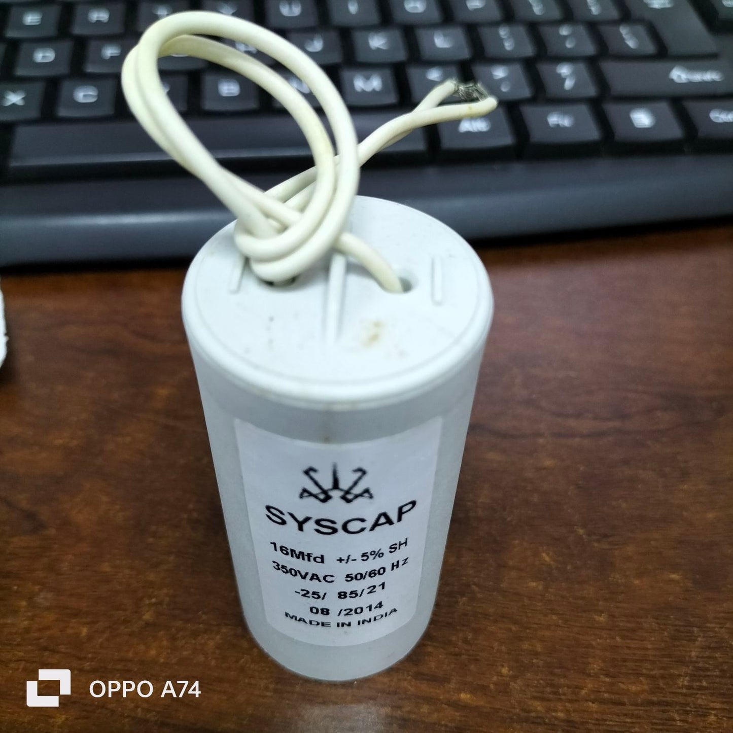 Syscap 16MFD Motor Running Capacitor 350VAC with attached white wires on wood surface