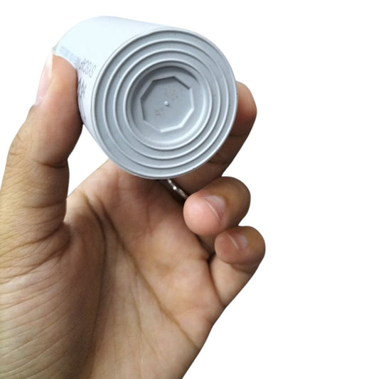 Hand holding a 23MFD 450VAC motor capacitor from Syscap electrical circuitry parts