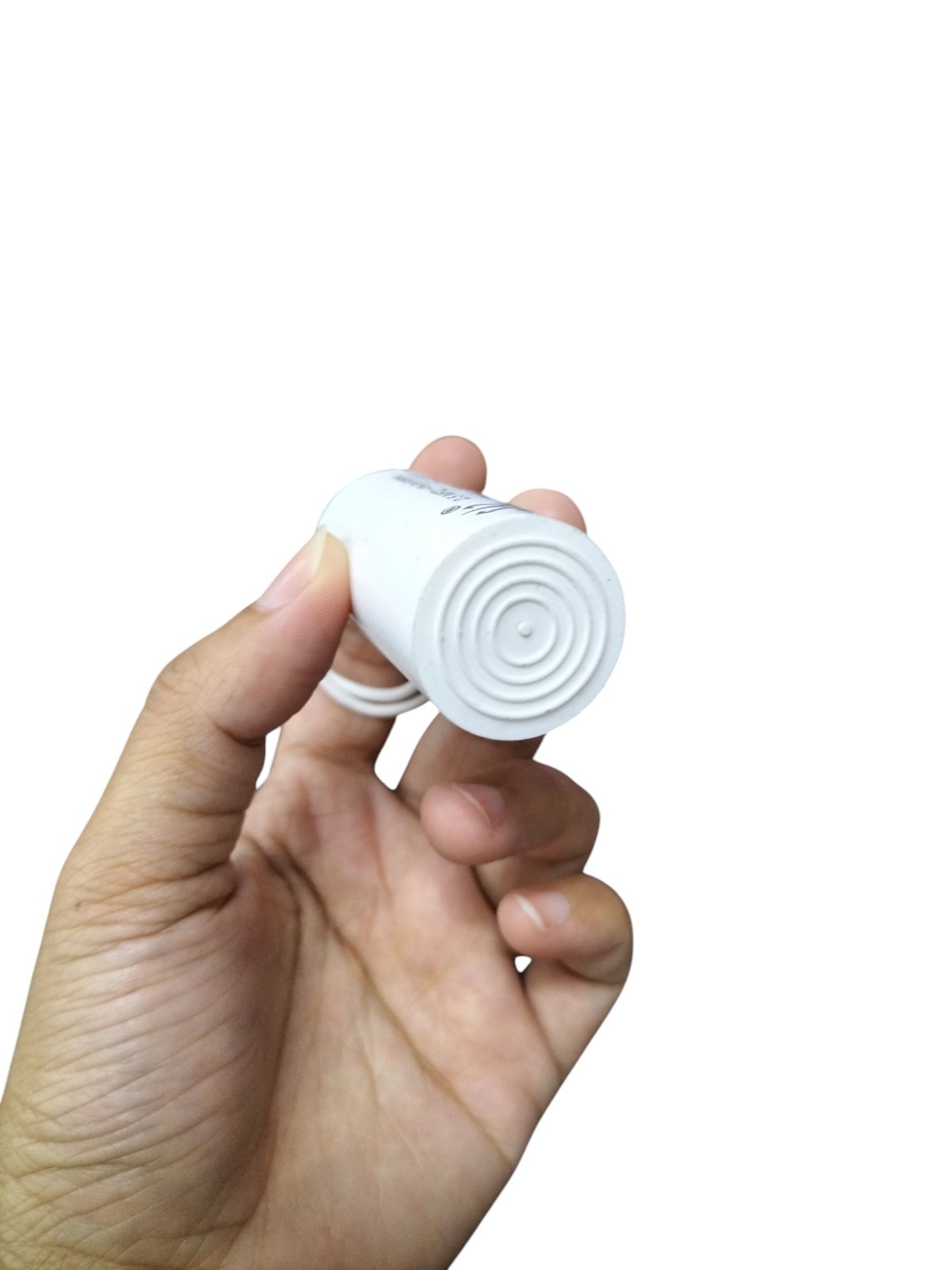 Hand holding white 3.75uF 250V AC capacitor from Syscap electrical circuitry parts