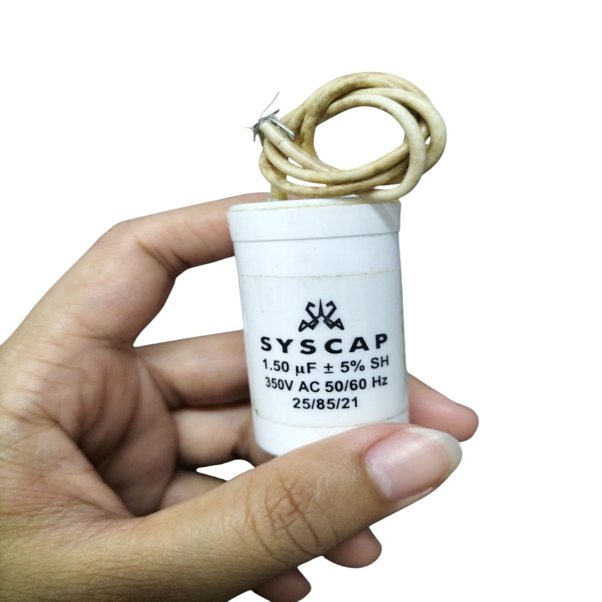 SYSCAP 350VAC running capacitor with 1.50 μF rating held in hand for electrical applications