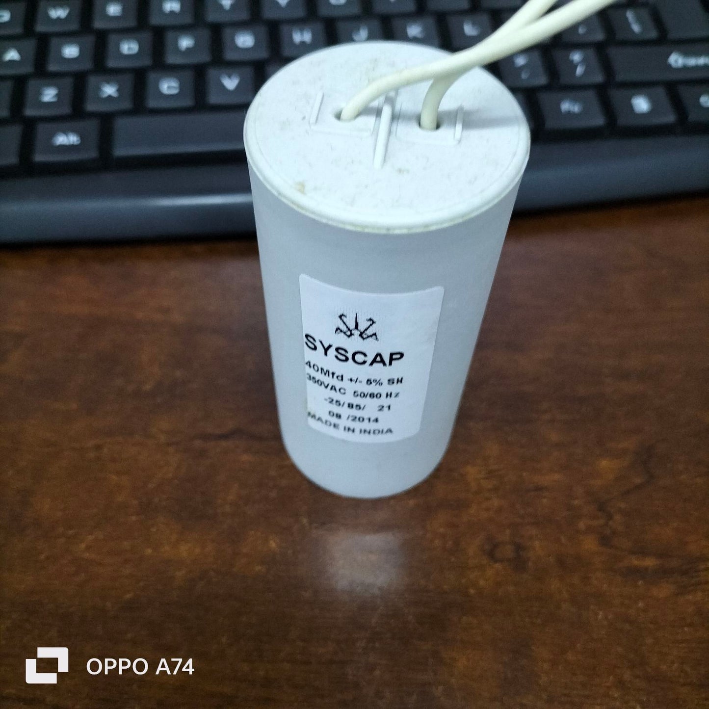 Syscap 40MFD 350 VAC Running Capacitor cylindrical electrical component with two wires on brown surface