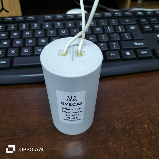 Syscap 50MFD 350V AC Running Capacitor with white wires on wooden surface near keyboard