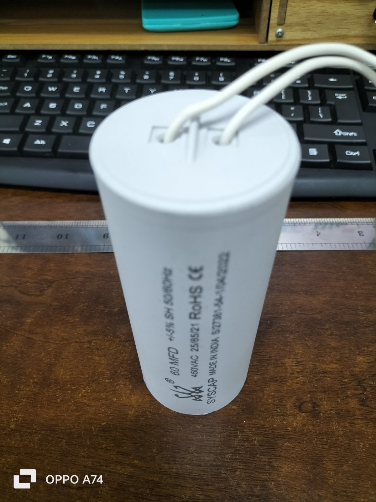 Syscap 60MFD 450V AC motor running capacitor cylindrical white with wires on wooden table