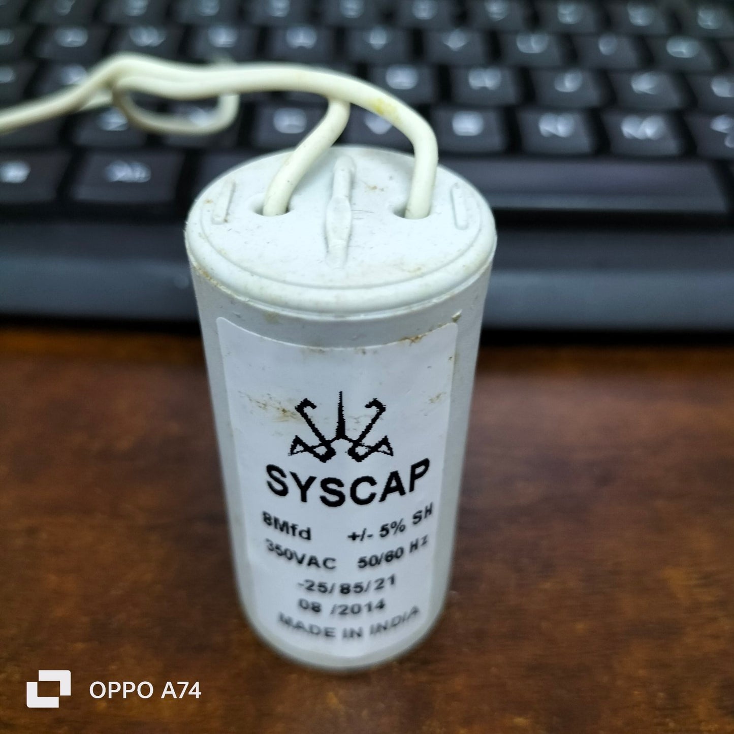 Syscap 8 Microfarad Motor Run Capacitor white cylindrical electrical part on desk