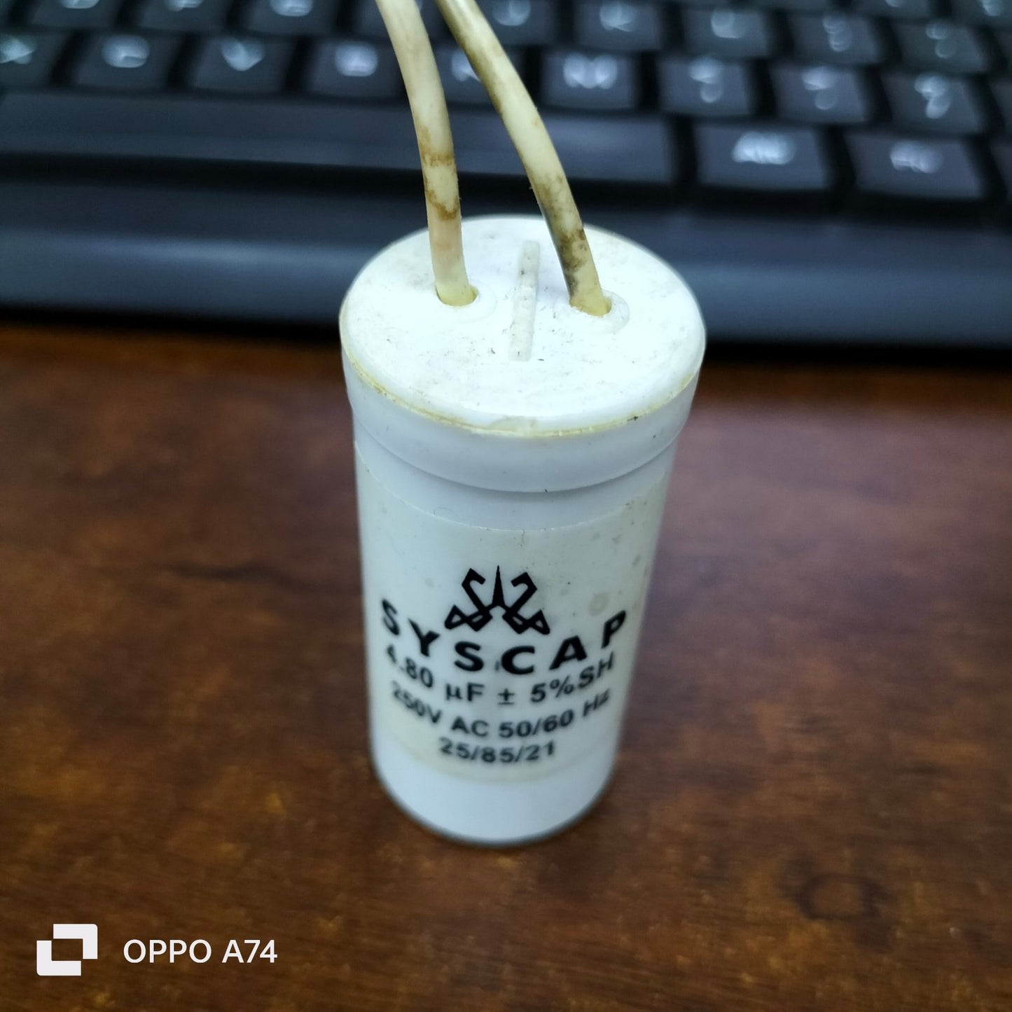 SYSCAP motor capacitor 4.8MFD white cylindrical electrical component with wires on wooden surface