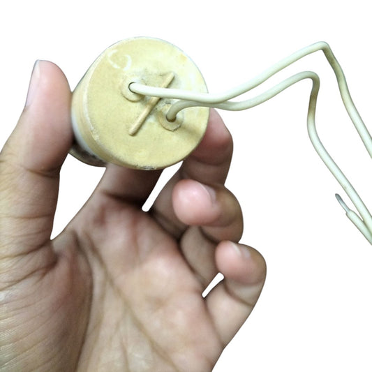 Hand holding SYSCAP Motor Running Capacitor 1MFD 600V AC with attached white wires