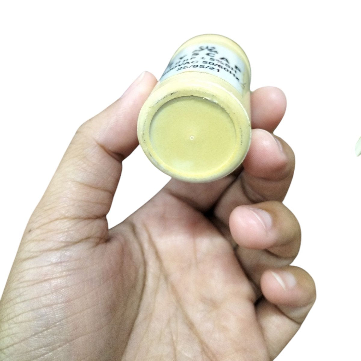 Hand holding SYSCAP Motor Running Capacitor 1MFD 600V AC electrical component