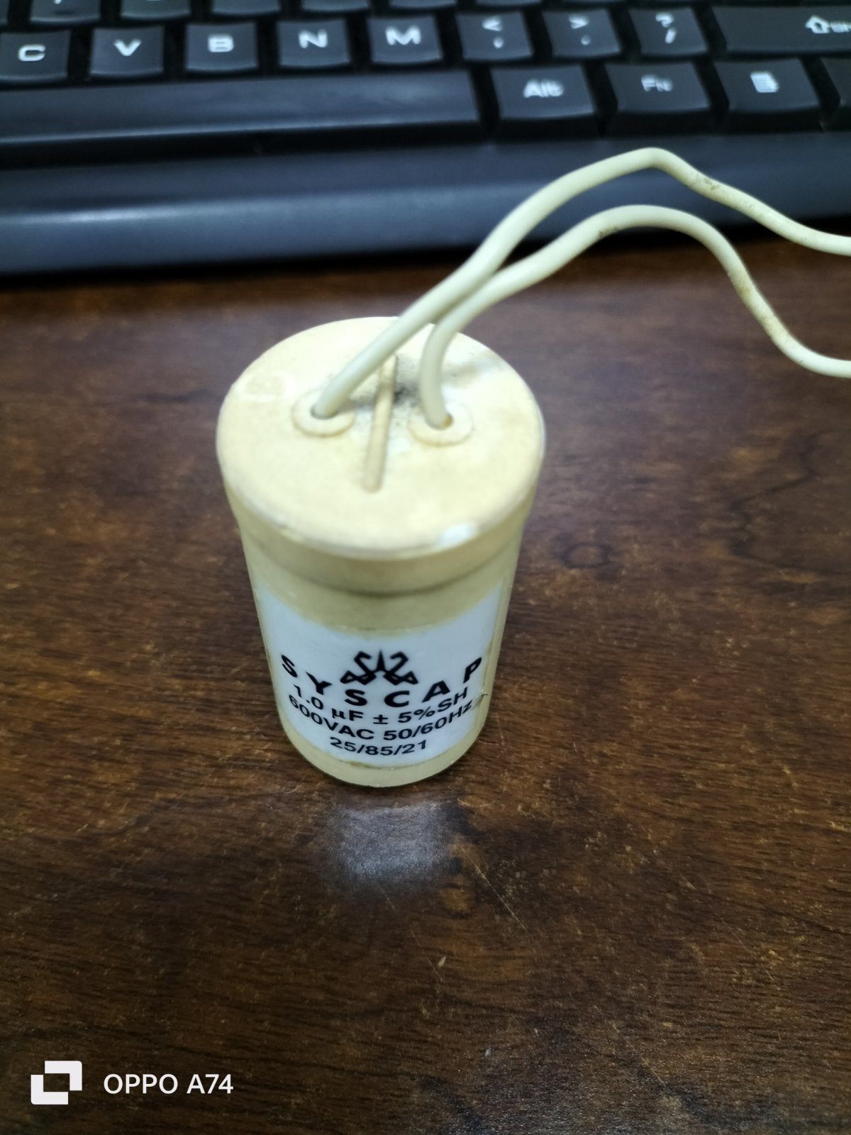 SYSCAP Motor Running Capacitor 1MFD 600V AC cylindrical electrical component with two white wires on wooden surface