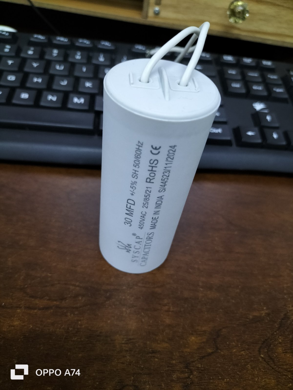 Syscap motor running capacitor 30 MFD electrical component with wires.