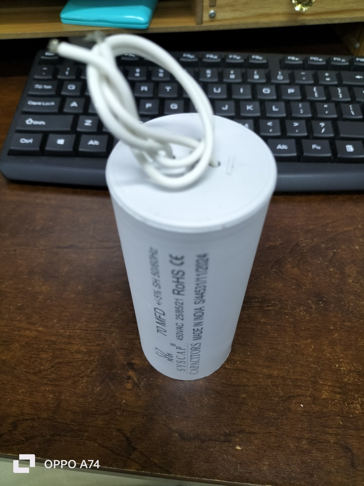 SYSCAP Motor Running Capacitor 70MFD 450V AC cylindrical white capacitor on wooden desk with keyboard in background