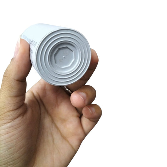 Hand holding SYSCAP Motor Running Capacitor 90MFD 450V AC with white cylindrical body