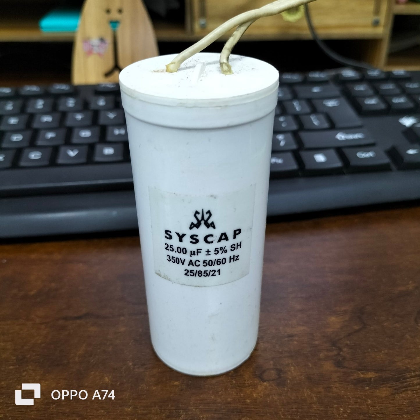 Syscap Running Capacitor 25MFD 350 VAC cylindrical electrical component with wires on wooden desk