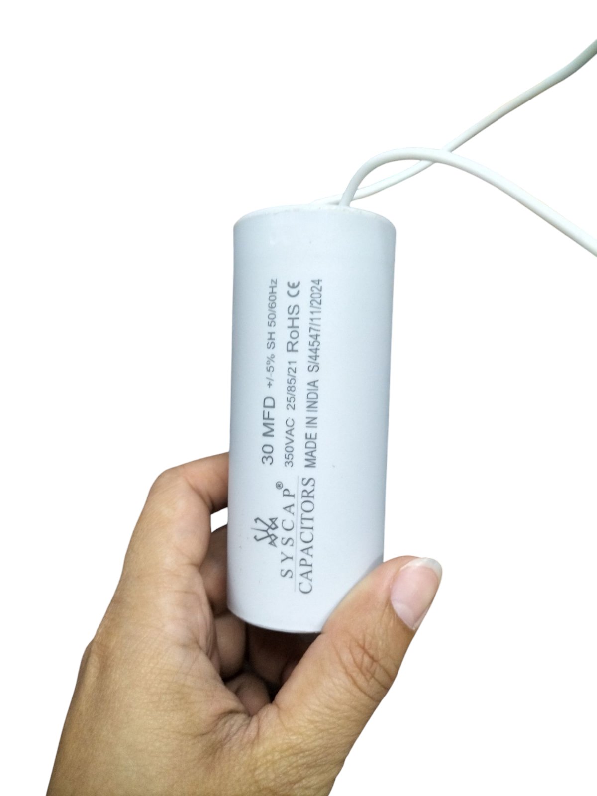 Syscap Running Capacitor 30MFD 350 VAC held in hand with white wires attached