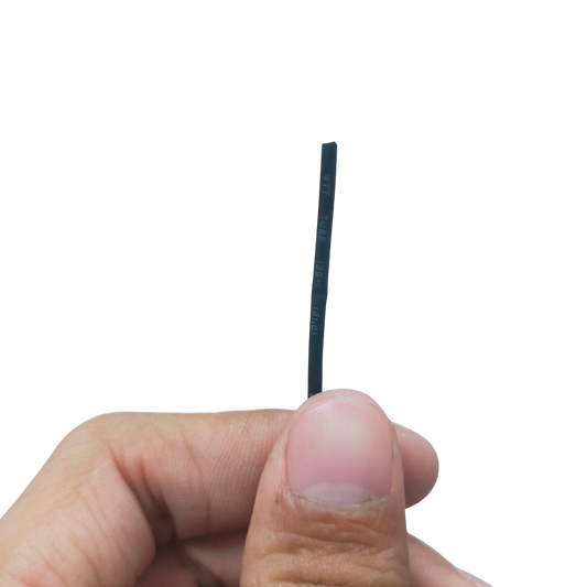 Hand holding a thin black Heat Shrinkable Tube Black - 1mm for cable management against black background