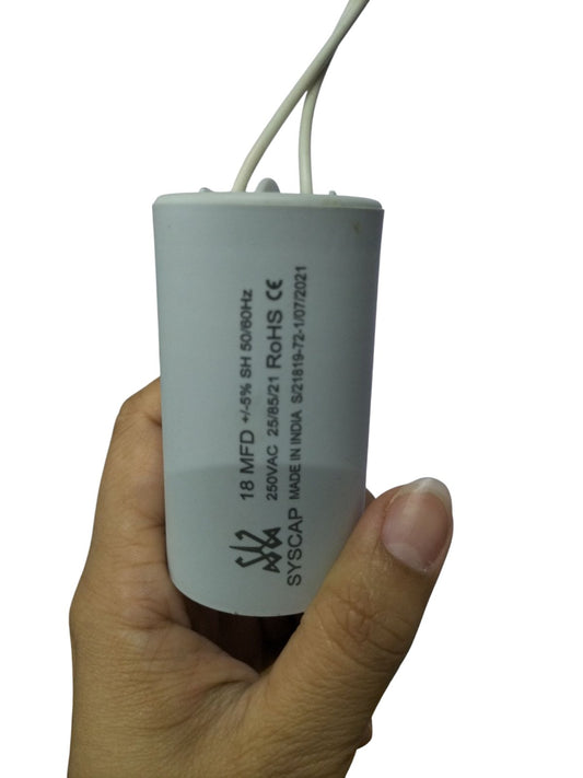 Syscap 18MFD 250 VAC Running Capacitor held in hand with white wires for electrical applications