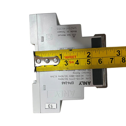 A white electrical analog module with a yellow tape measure laid across it to show its width, photographed on a plain white background.