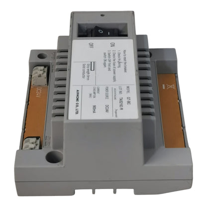 A gray industrial electrical module with a white label and orange terminal strips, photographed on a plain white background.