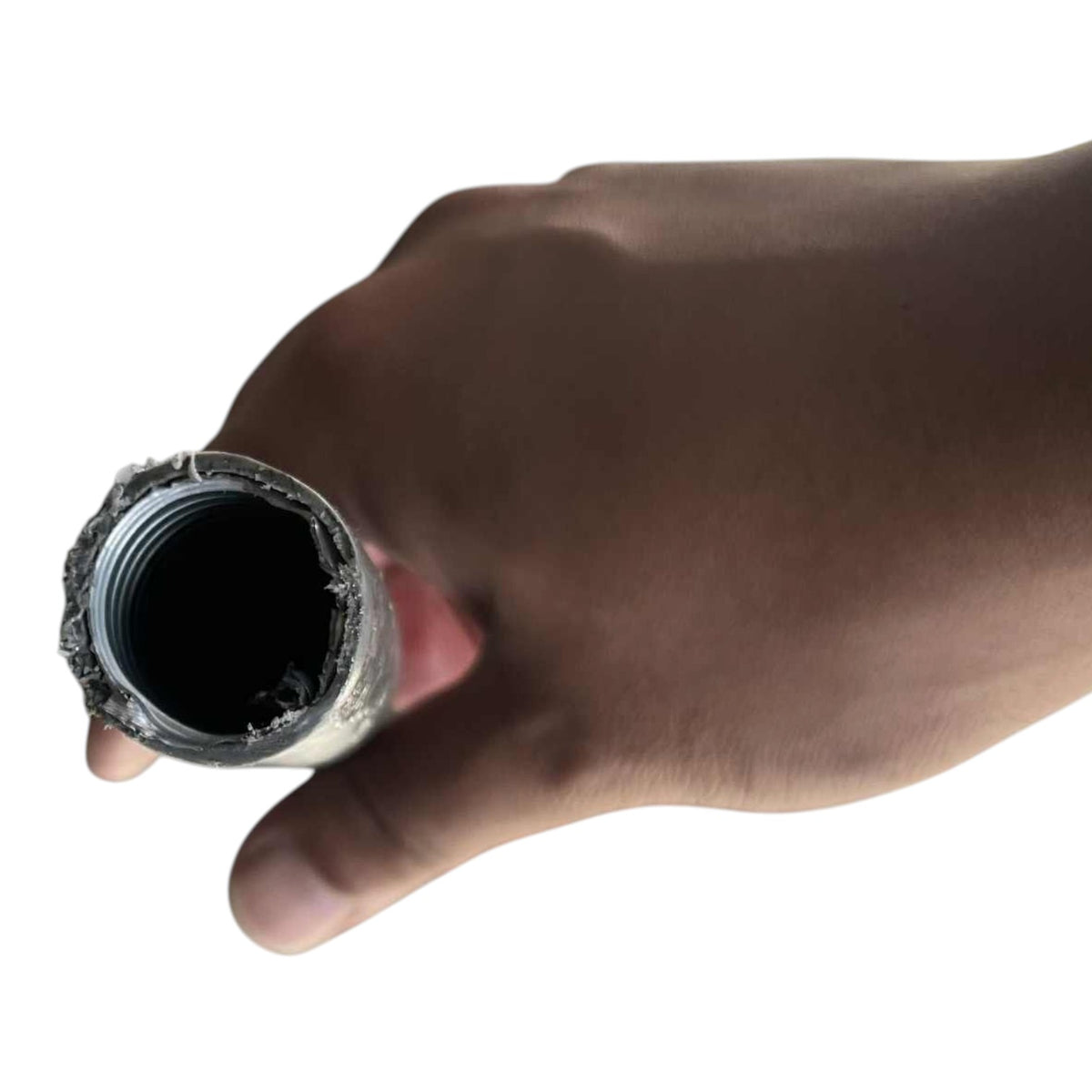 A close-up of a hand holding a cylindrical metal pipe fitting or tube end against a plain white background.
