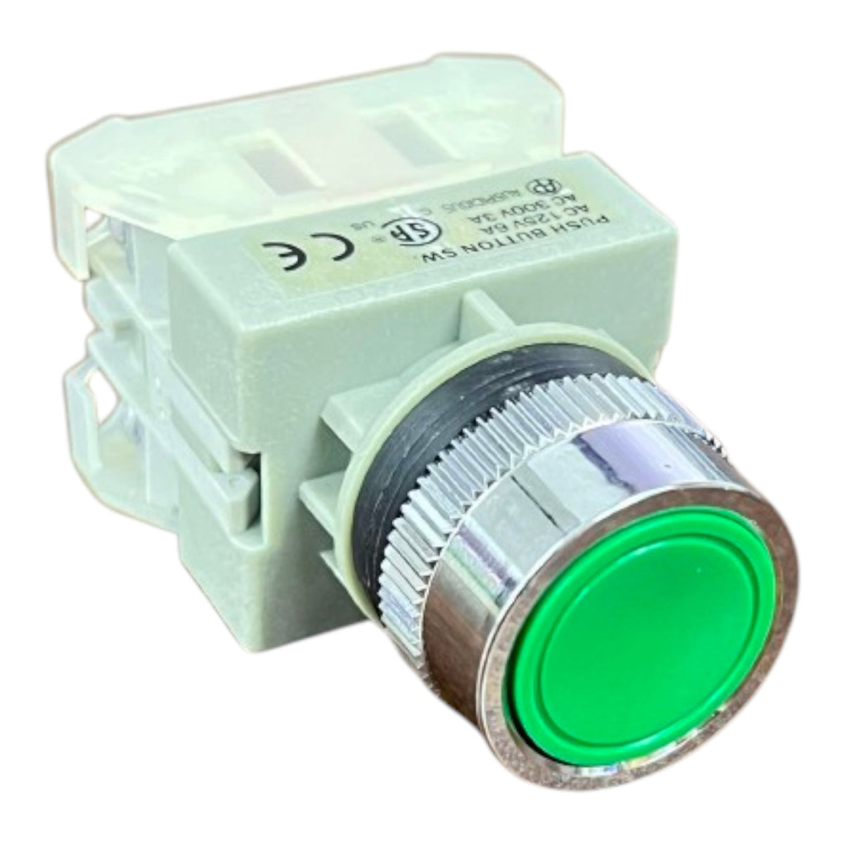 A push button switch with a light green plastic housing, a silver metal ribbed bezel, and a bright green circular button face, shown on a plain white background.
