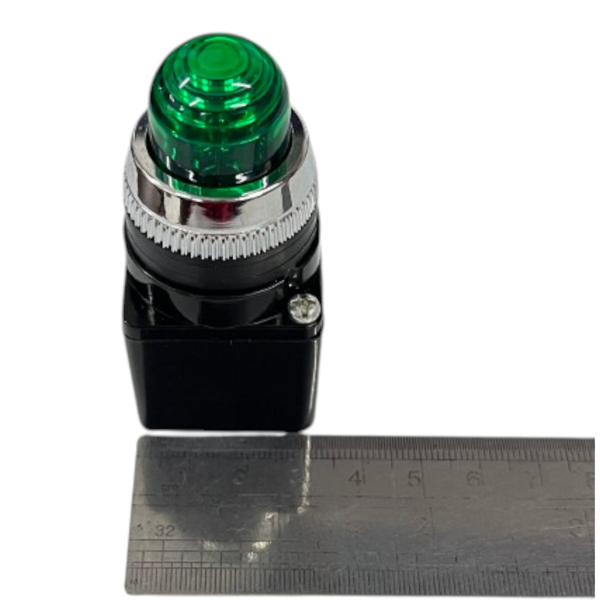 A green button with a black base and silver metal collar, shown next to a metal ruler for scale on a white background.