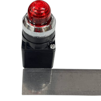 A red dome-button style electrical switch with a black housing and silver metal collar, shown next to a metal ruler on a white background.